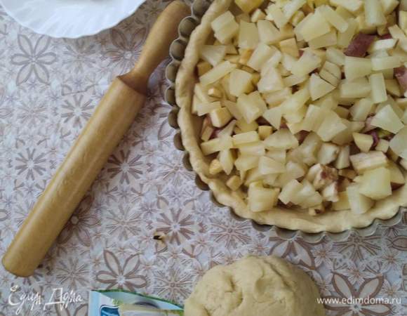 Делим наше тесто на две неравные части, побольше и поменьше. То что больше будет у нас дном с бортами. Выкладываем в форму и на него начинку. Сахар в начинку не добавляю. Яблоки и ананас достаточно сладкие.