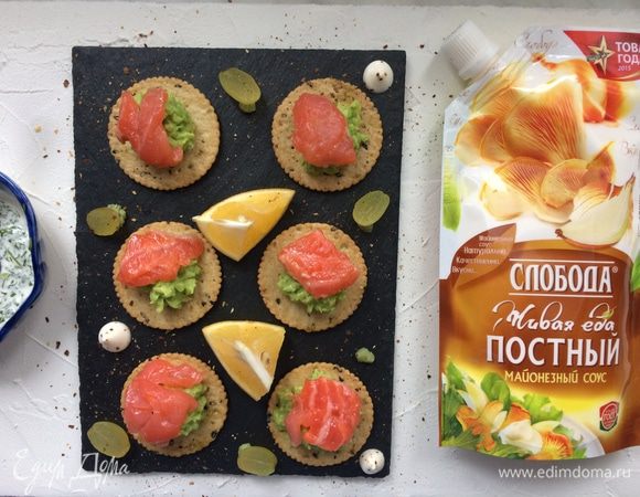 Сверху выложите ломтики семги и приправьте соусом с зеленью.