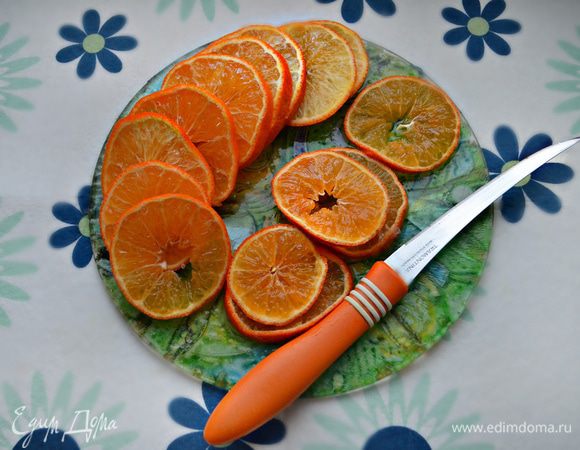 Тем временем мандарины нарежьте тонкими кружочками, сок слейте.