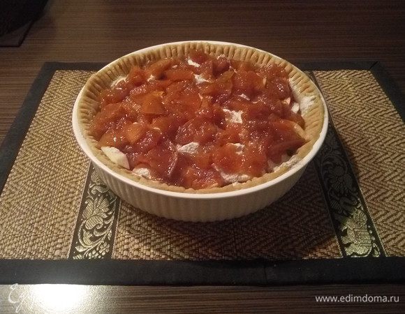 Достать форму из холодильника, отложить 1/3 теста и наполнить форму яблоками почти по самый бортик. Равномерно посыпать яблоки смесью муки и ванильной пудры, затем равномерно выложить варенье по всему диаметру. Слой должен быть небольшим, еле покрывающим поверхность. 
Вместо варенья можно использовать джем, со вкусами можно тоже экспериментировать: грушевое, персиковое и т.д.
Если вы используете ревень, то стоит добавить сахар, соотношение муки и сахара при этом должно быть где-то 100 г и 50 г соответственно.
Если сливы: 75 г муки и 25 г сахара. Смысл в том, что мука впитывает лишнюю влагу, которую выделяет начинка, чем влаги больше, тем больше нужно муки. Ну и чем начинка кислее, тем больше необходимо сахара. В яблочный я вообще сахар не добавляю, хватает ванильного и варенья, правда, если сорт яблок кислый, то немного можно, тут уже каждый выбирает по вкусу.