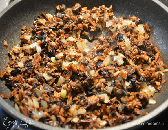 Обжарить лук до золотистой корки, добавить грибы, немного обжарить, добавить воду, в которой замачивались грибы и тушить до выпаривания жидкости. 