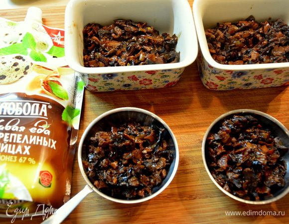 Выложить грибы в кокотницы, полить соусом.