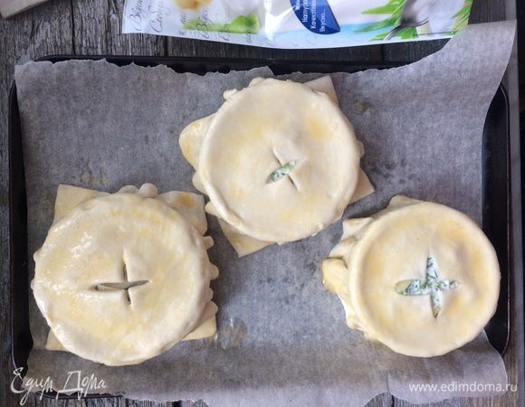 Лист теста разделите на 4 части и раскатайте до толщины 4 мм, и накройте каждую кокотницу тестом. Защипните края. Обрежьте лишнее тесто, прорежьте в центре крест и смажьте тесто яйцом. 