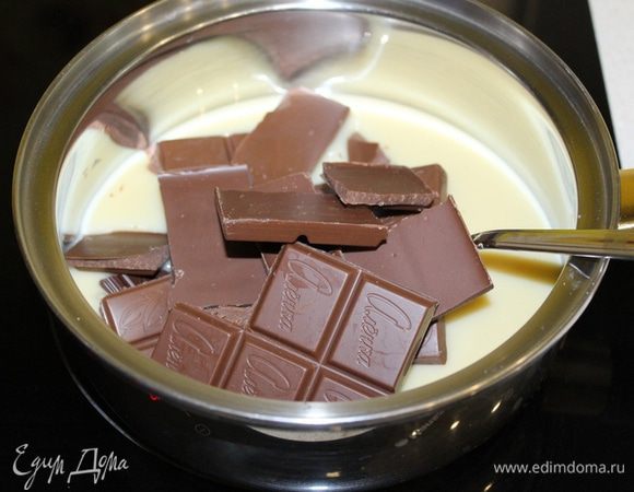 Клюкву залейте коньяком. Оставьте, чтобы жидкость впиталась.
В кастрюле соедините сгущенное молоко и шоколад, поломанный на кусочки. Нагревайте на среднем огне, постоянно помешивая, примерно 5 минут, 