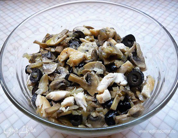 В чашке смешиваем куриное мясо с грибами, луком и маслинами. Сыр натираем на крупной терке.