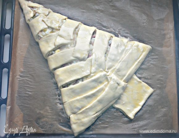 Края теста заверните друг на друга, формируя елочку. Ствол «дерева» можно сложить пополам и слегка примять. Смазать обильно яйцом и отправить в разогретую до 200 г духовку на 50 — 55 мин. Если «ствол» елочки быстро зарумянивается, его можно будет прикрыть фольгой, чтобы не пригорел.