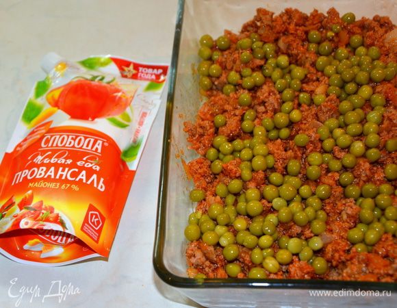 Выложить мясо в форму для запекания, добавить зеленый горошек.