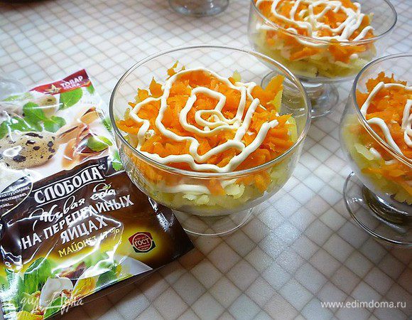 Сверху на картофель укладываем натертую на крупной терке морковь и опять промазываем майонезом.