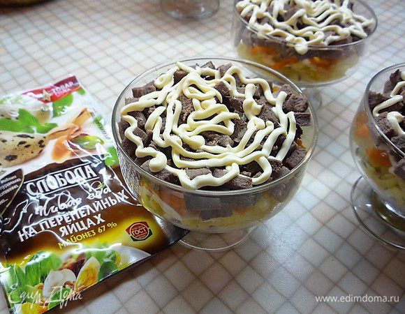 На морковь укладываем нарезанный маленькими кубиками свиной язык, промазываем майонезом.