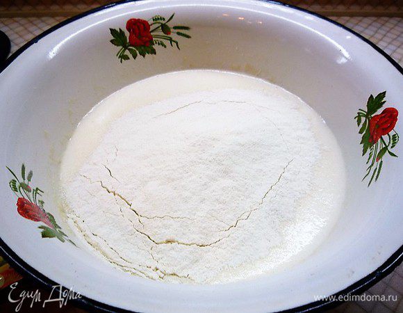 Подсыпаем просеянную муку и замешиваем тесто.