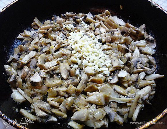 Для начинки лук мелко нарезаем, обжариваем в сливочном масле до золотистого цвета, добавляем нарезанные крупными дольками грибы, жарим, пока не выпарится жидкость примерно 7 — 10 минут, добавляем мелко нарезанный чеснок, солим, перчим, добавляем специи, все хорошенько перемешиваем и выключаем.
