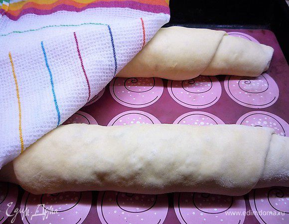 Укладываем рулеты на противень, накрываем влажным кухонным полотенцем и оставляем на 1 час, время от времени сбрызгиваем полотенце теплой водой.