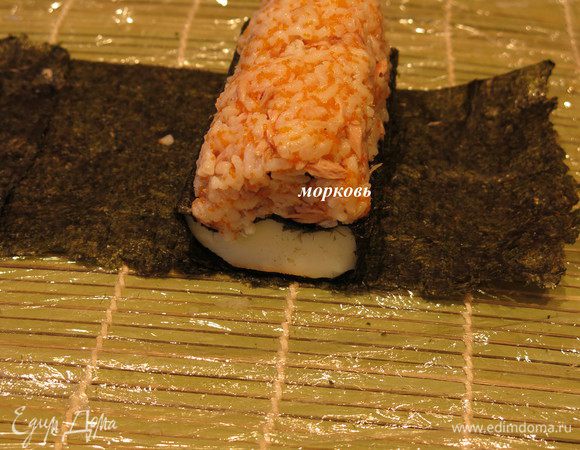 Кладем по середине полоску моркови и на нее еще рис.