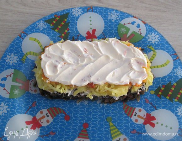 Утрамбовывать его не нужно, пусть будет рыхлый или разреженный, а вот укрыть слоем майонеза нужно.