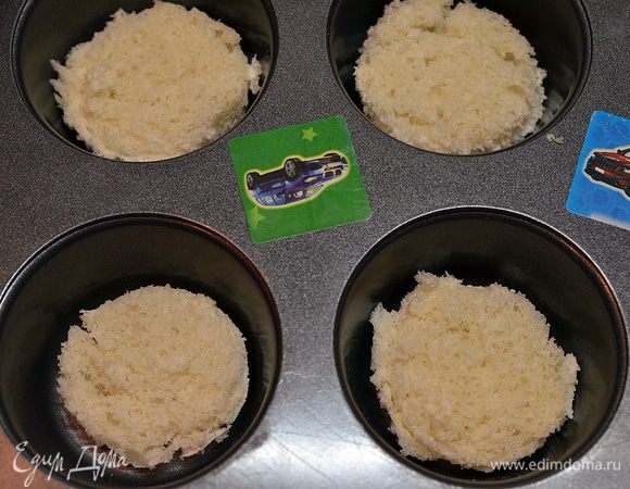 Из хлеба рюмкой подходящего размера вырезать кружки и выложить в формочки.