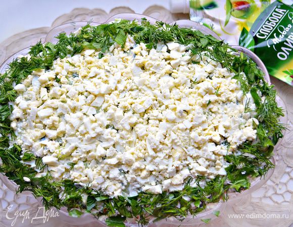 И в заключение, слой рубленных яиц. Украшаем по краю блюда рубленной зеленью.