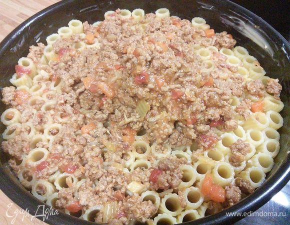 Соус болоньезе разогреть, если он успел остыть, и распределить его по поверхности пирога. Если вы купили правильные ригатони (мне к сожалению не удалось найти именно их), то рагу беспрепятственно распределиться вдоль пасты и заполнит ее. 