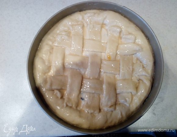 Подгибаем бортики теста и украшаем сверху решеткой из оставшейся 1/4 части теста. Для этого раскатываем оставшееся тесто с помощью скалки в круг, нарезаем полосками и выкладываем решетку сверху на начинку.
Оставшийся от приготовления теста, желток смешиваем вилкой с молоком и смазываем этой смесью с помощью кисточки тесто сверху.