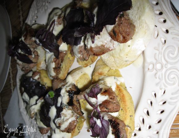 Собираем брускетты. На хлеб выложить несколько кусочков печени, полить соусом и украсить свежим базиликом. Можно подавать к столу закуску. Приятного аппетита и хорошего настроения!