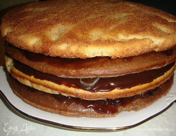 Дальше укладываем шоколадный корж, смазываем его клубничным джемом и накрываем маковым коржом.