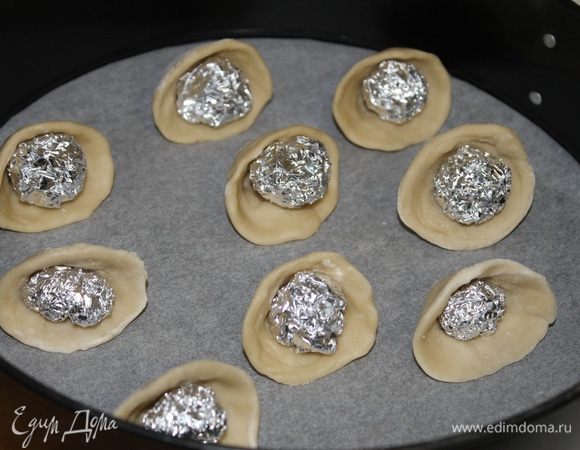 Из слоеного теста сделайте тарталетки. Я готовила слоеное тесто сама и сформировала тарталетки в форме ракушки. Что бы при выпечке тесто не потеряло форму, я из фольги сделала шарики и вложила внутрь колпачка.