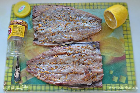 Филе рыб слегка посолите, сбрызните лимонным соком и смажьте горчицей.