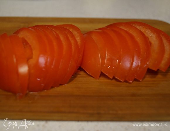 Полудольками режем помидоры.