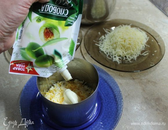 Салат можно собрать в большом салатнике, но порционная подача наряднее.
В кулинарное кольцо первым слоем положите яйца, посолив по вкусу, сверху нанесите тонкий слой майонеза. Следующим слоем кладется лук, который нужно отжать от маринада. На каждый последующий слой наносите майонез. 