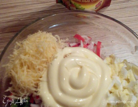 Соединяем компоненты: лук зеленый, крабовые палочки, яйца, сыр и заправляем майонезом. Получается салатная смесь.