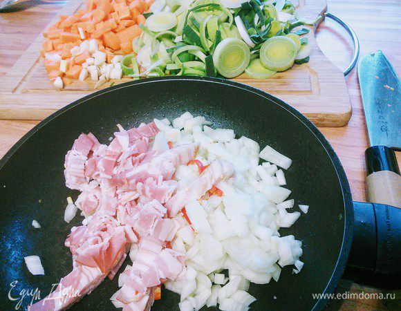 Лук и чеснок мелко порубить, порей нарезать кольцами, морковь — кубиком. Бекон также нарезать на кусочки.