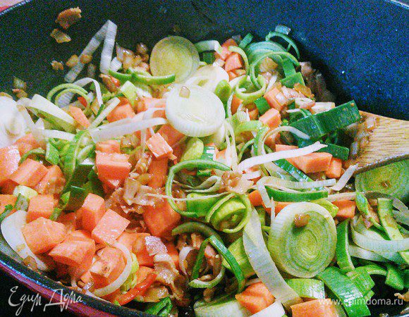 Добавить чеснок, порей и морковь, обжарить вместе еще пару минут. Присыпать овощи мукой и обжарить еще минутку. Я это упустила.