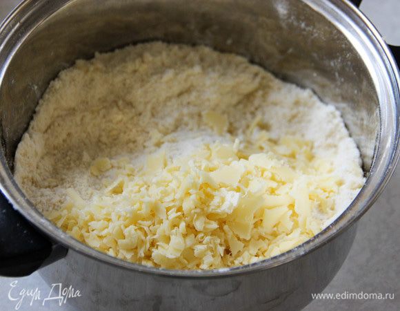 Натираем на мелкой терке сыр чеддер. Этот сорт я выбрала потому, что он не столь соленый, у него орехово-молочный ненавязчивый привкус. Кажется, самое то для такого пирога! Добавляем сыр в мучную смесь. Сюда же — охлажденную воду. 