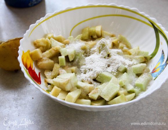 Тем временем займемся начинкой. Яблоки почистим и нарежем кубиками, добавим к ним лимонный сок, сахар, ванилин, муку. Перемешаем.