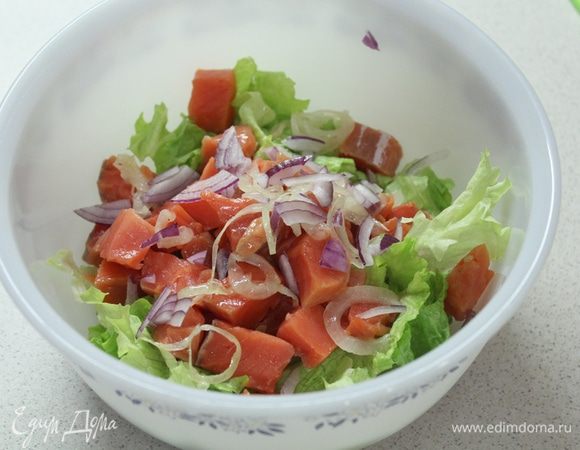 Листья салата рвем руками. Добавляем кусочки рыбы, нарезанный красный лук.