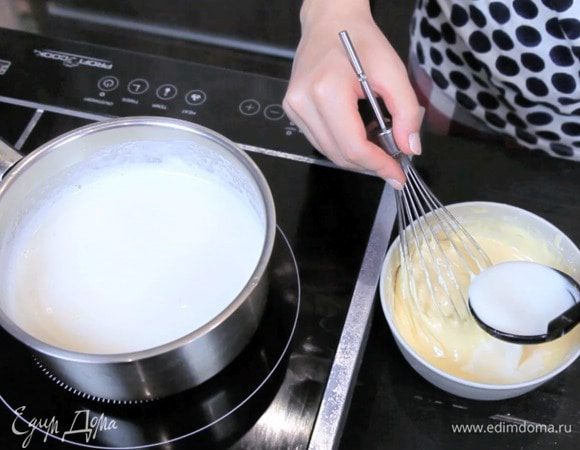 Влить в желтки 1/3 кипящего молока и сразу хорошо перемешать.