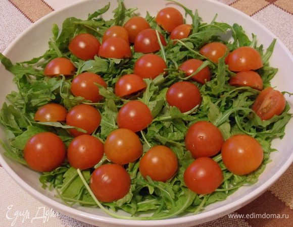 Смешиваем салатные листья с помидорками.