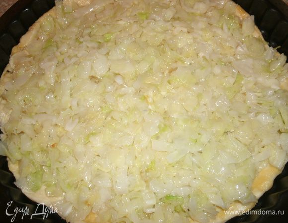 На тесто первым слоем выложить обжаренную и слегка остывшую капусту.