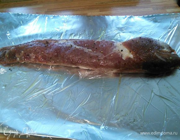 Свиную вырезку помыть, очистить от пленок и жилок. На лист фольги (я стараюсь избегать прямого контакта фольги с пищевыми продуктами, особенно если присутствуют соль или кислота, потому что при взаимодействии с алюминием выделяются вредные для здоровья вещества. Поэтому я выкладываю на лист фольги пищевую пленку, а уже на нее мясо). Мясо с обеих сторон посолить и поперчить, смазать оливковым маслом, завернуть в фольгу и отправить в заранее разогретую до 180°С духовку на 30 мин. Затем температуру снизить до 120°С и запекать еще 1 — 1,5 часа. Чем дольше, тем мягче и нежнее будет мясо. Андрей говорит, что подойдут также и др. части свиной туши, такие как шея или окорок. В этом случае запекать мясо можно и дольше. 