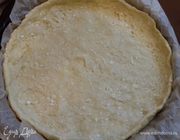 Распределить тесто по дну разъемной формы для выпечки и сделать небольшие бортики. Я использовала бумагу для выпечки, чтобы затем было легче доставать пирог. 