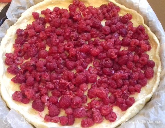 Выложить поверх теста ягоды малины.