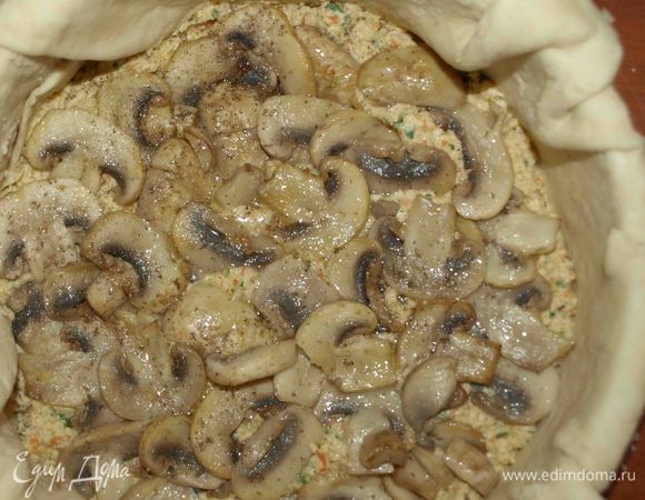 Берем глубокую форму для запекания. У меня 8 см глубина и 20,5 диаметр. На присыпанной мукой поверхности  раскатать большую часть теста. Перекладываем тесто в форму. Выкладываем часть начинки, выкладываем слоем грибы. Грибы солим, перчим.