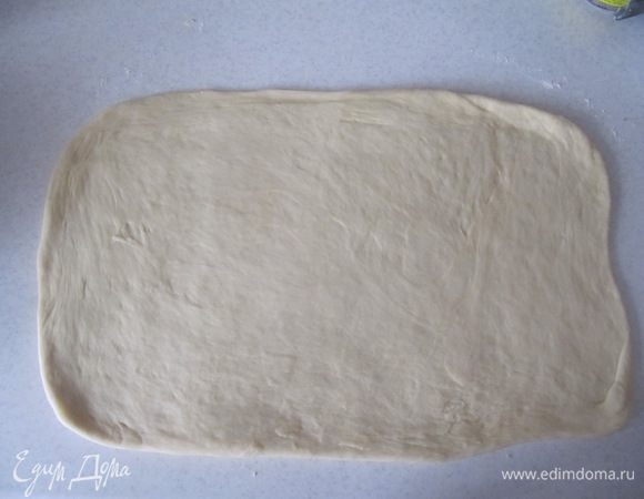 Тесто раскатать на слегка присыпанной мукой поверхности в прямоугольник размером приблизительно 45x23 см.