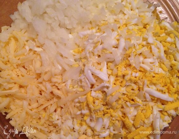 Приготовить начинку. Три яйца сварить вкрутую, очистить и натереть на крупной терке. Натереть сыр. Лук мелко порубить.