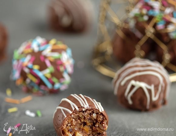 Готовые шарики я предлагаю заглазировать и украсить по желанию. На водяной бане топим любимый шоколад (у меня молочный), зубочисткой или, как делаю я, деревянной шпажкой — накалываем шарик и глазируем, излишки шоколада стряхиваем. Украшаем по желанию: у меня это разноцветные сахарные посыпки и белый шоколад. Готовые конфеты ставим в холодильник до застывания шоколада.