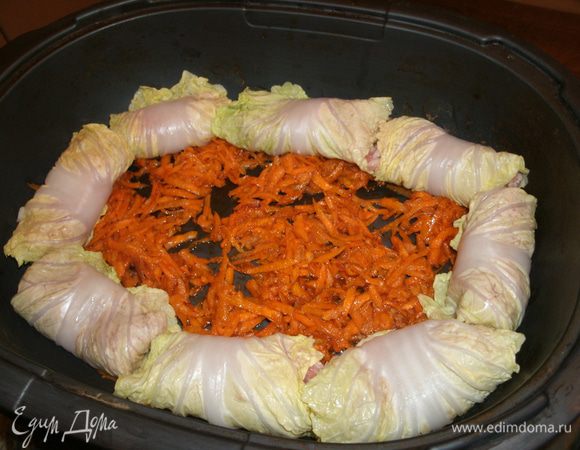 Выкладывать завернутые голубцы в посуду для тушения, поверх поджарки из моркови. 