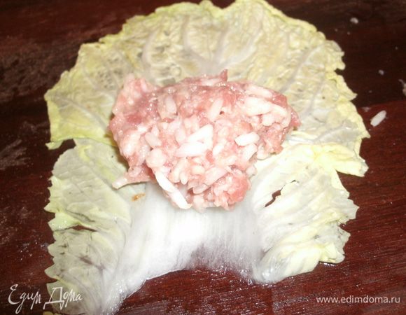 У подготовленных листов капусты срезать утолщения. К одному краю положить 1 — 2 ст. л. начинки (размер голубцов будет зависеть от размера листьев капусты), завернуть в рулетик, подбирая края. 