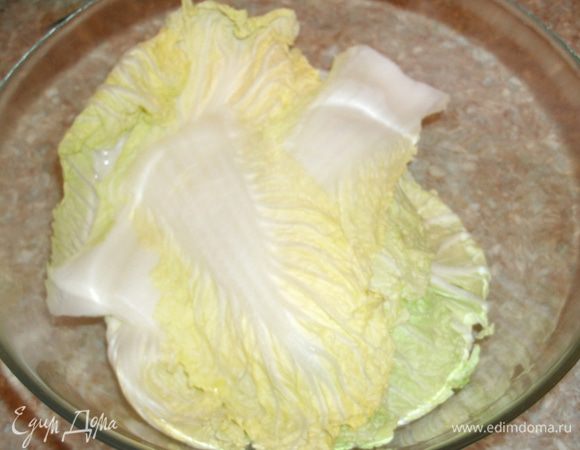 Кочан пекинской капусты разобрать на листочки. В чашку сложить 5 — 7 листочков и греть в микроволновке 5 минут на максимальной мощности. В результате этой процедуры листья станут мягкими и будут заворачиваться, не ломаясь. 