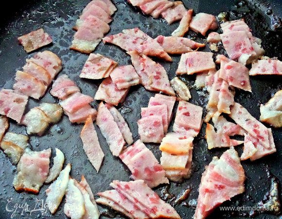 Ветчину или бекон нарезать и бросить на сковороду, обжарить слегка.