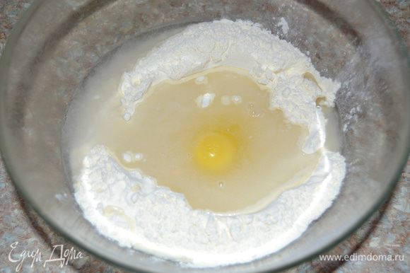Всыпать в миску две трети муки и в центре сделать углубление. Размешать соль в стакане холодной воды, вылить в муку, туда же разбить яйцо. Для вареников используем белую пшеничную муку высшего сорта, чтобы и вареники получились белыми.