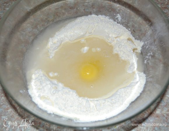 Всыпать в миску две трети муки и в центре сделать углубление. Размешать соль в стакане холодной воды, вылить в муку, туда же разбить яйцо. 
Для вареников используем белую пшеничную муку высшего сорта, чтобы и вареники получились белыми. 